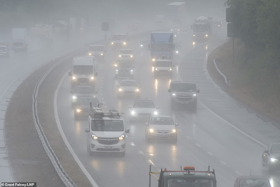 Køretøjer kører langs den meget våde M25 nær Swanley i Kent i går, da kraftig regn skaber overfladesprøjt og reducerer sigtbarheden