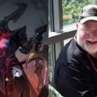 Rhaast (left) from League of Legends, and his voice actor Sam Mowry (right).